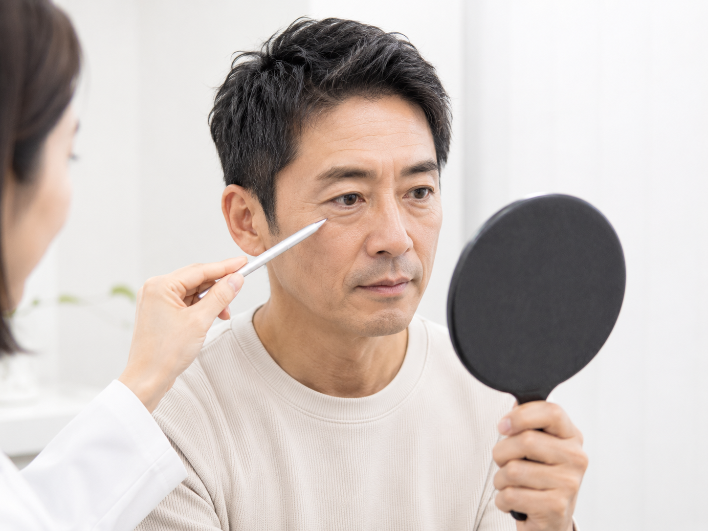 鏡で目元を確認する男性